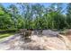Spacious stone patio with outdoor seating surrounded by trees and greenery at 2960 Millwater Xing, Dacula, GA 30019