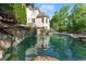 Beautiful backyard pool with rock waterfall feature and surrounding greenery at 2960 Millwater Xing, Dacula, GA 30019