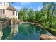 Scenic view of the pool with a waterfall feature surrounded by lush trees at 2960 Millwater Xing, Dacula, GA 30019