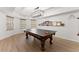 Recreation room showcasing a well-lit ping pong table on wood flooring, perfect for entertaining guests at 2960 Millwater Xing, Dacula, GA 30019