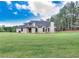 Lush, expansive backyard with mature trees and a covered patio at 2106 Lacroix Way, Conyers, GA 30094