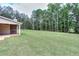 Large, private backyard with an outdoor fireplace and a wooded backdrop at 2106 Lacroix Way, Conyers, GA 30094