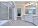 A spacious bathroom has a separate tub and shower with grey tiling and a double vanity at 2106 Lacroix Way, Conyers, GA 30094