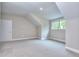 Cozy bedroom featuring neutral carpeting, sloped ceilings, a large window, and fresh white trim at 2106 Lacroix Way, Conyers, GA 30094