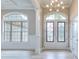 Inviting foyer with decorative glass double doors, chandelier, and expansive windows showcasing the home's exterior at 2106 Lacroix Way, Conyers, GA 30094