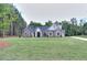 Beautiful gray brick home with manicured lawn and landscaping, and a long driveway at 2106 Lacroix Way, Conyers, GA 30094