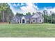 Elegant, single-story brick home featuring a manicured lawn and classic architectural details at 2106 Lacroix Way, Conyers, GA 30094