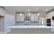 Bright kitchen features white cabinets, stainless steel appliances, an island, and stylish pendant lighting at 2106 Lacroix Way, Conyers, GA 30094