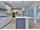 Bright kitchen features white cabinets, stainless steel appliances, an island, and stylish lighting at 2106 Lacroix Way, Conyers, GA 30094