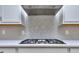 Herringbone backsplash over a gas range and stainless vent hood in a modern kitchen at 2106 Lacroix Way, Conyers, GA 30094
