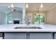 Close-up of a kitchen island with stainless sink and a view into a living room with a fireplace at 2106 Lacroix Way, Conyers, GA 30094