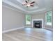 A cozy living room features a fireplace, light wood floors, white trim, and tray ceilings at 2106 Lacroix Way, Conyers, GA 30094