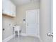 A clean mudroom features a sink, tiled floor, and utility closet at 2106 Lacroix Way, Conyers, GA 30094