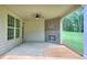 Covered patio features a brick fireplace, ceiling fan, concrete flooring, and view of wooded backyard at 2106 Lacroix Way, Conyers, GA 30094