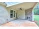 Covered patio features a brick fireplace, ceiling fan, concrete flooring, and view of wooded backyard at 2106 Lacroix Way, Conyers, GA 30094