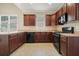 Well-lit kitchen featuring warm wood cabinetry, neutral countertops, and modern black appliances at 3606 High Battery Nw Blf, Acworth, GA 30101