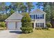 Tan two-story house featuring a two-car garage and manicured lawn at 1331 Pine Acre Dr, Sugar Hill, GA 30518