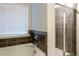 Bathroom with white tub, tile walls, brushed fixtures, and glass enclosed shower at 3004 Amabile Rd, Dacula, GA 30019