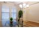 Dining room featuring a glass table, three windows, and a decorative plant at 3004 Amabile Rd, Dacula, GA 30019