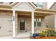 Charming front porch with brick accents, a dark-colored front door and lovely potted plants at 3004 Amabile Rd, Dacula, GA 30019