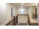A carpeted hallway with wood railing offers plenty of natural light from a window at 3004 Amabile Rd, Dacula, GA 30019