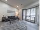 Spacious living room featuring bay windows, grey sofa, and hardwood floors at 2125 Jessica Way, Lithonia, GA 30058