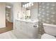 Bright bathroom with double sink vanity, framed mirror, and neutral patterned wallpaper at 234 Ashford Cir, Atlanta, GA 30338