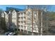 Exterior view of a tan condo building with white balconies and a tree at 234 Ashford Cir, Atlanta, GA 30338