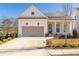 White farmhouse exterior with taupe garage doors and a covered porch at 210 Idylwilde Way, Canton, GA 30115