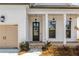 Front entry with dark gray door and brick steps leading to a covered porch at 210 Idylwilde Way, Canton, GA 30115