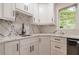 White kitchen corner sink and cabinetry with marble backsplash at 2911 Bentwood Dr, Marietta, GA 30062