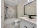 Stylish bathroom with marble tile, a shower over tub, a modern vanity, and black hardware at 3714 Thunder Ne Way, Marietta, GA 30066