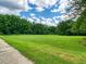 Large grassy field with lush green trees and blue skies at 147 Bluffington Way, Marietta, GA 30066