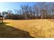 Expansive backyard featuring lush lawn and mature trees under a bright blue sky at 2571 Se Ebenezer Rd, Conyers, GA 30094
