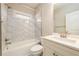 Bathroom featuring a shower-tub combo, white marble tile surround, and a white marble vanity at 2571 Se Ebenezer Rd, Conyers, GA 30094