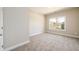 Bright, carpeted bedroom featuring neutral walls and a large window with scenic outdoor views at 2571 Se Ebenezer Rd, Conyers, GA 30094