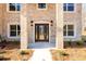 Elegant front entrance featuring a decorative glass door, brick columns, and manicured shrubbery at 2571 Se Ebenezer Rd, Conyers, GA 30094
