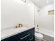 Bright bathroom featuring a vanity with blue cabinets, modern gold fixtures, a tub and white subway tile at 2290 Wilkins Cv, Decatur, GA 30035