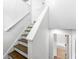 Stairway featuring white walls and natural wood stairs, leading to additional living spaces with natural lighting at 2290 Wilkins Cv, Decatur, GA 30035