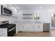 Modern kitchen with white cabinets, stainless steel appliances and quartz countertops at 488 Village Run, Lawrenceville, GA 30046