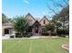 Charming stone home featuring manicured landscaping, a portico, gabled roof and a lush, green lawn at 1255 Mcminn Way, Snellville, GA 30078