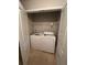 Convenient laundry closet equipped with a washer, dryer, and shelving for storage at 1060 S Creek Dr, Villa Rica, GA 30180