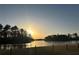 Scenic view of the sun rising over a calm lake surrounded by lush trees and green lawn at 1060 S Creek Dr, Villa Rica, GA 30180