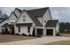 Two-story farmhouse-style home with white siding, dark roof, and attached garage at 4730 Down Setting Rd, Cumming, GA 30028