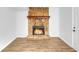 Stone fireplace with wood mantel in a room with light walls and wood-look flooring at 2729 Oxford Dr, Decatur, GA 30034