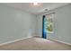 Bedroom featuring neutral walls, patterned carpeting, and a window with blue curtains at 4127 Conley Pond Ct, Decatur, GA 30034