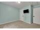 Bedroom showcasing blue walls, patterned carpeting, and a wall-mounted television at 4127 Conley Pond Ct, Decatur, GA 30034