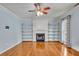 Light-filled living room features a cozy fireplace, built-in shelving, a ceiling fan and beautiful hardwood floors at 4127 Conley Pond Ct, Decatur, GA 30034