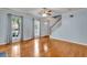 Spacious living room featuring hardwood floors, staircase, two bright windows and a ceiling fan at 4127 Conley Pond Ct, Decatur, GA 30034
