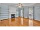 Bright living room with a fireplace, built-in shelving, ceiling fan, hardwood floors, and windows with decorative curtains at 4127 Conley Pond Ct, Decatur, GA 30034